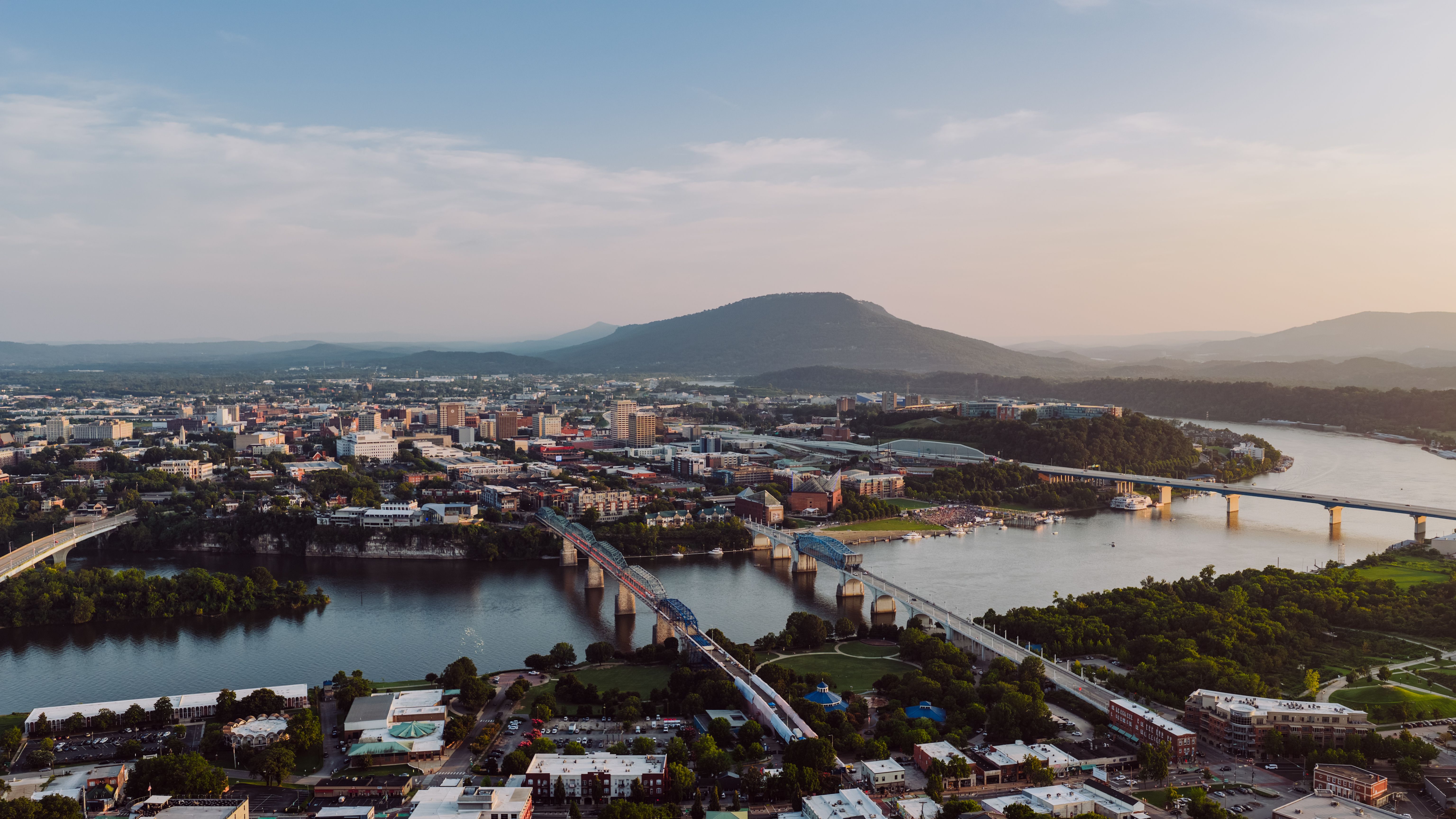 Aerial view of Chattanooga with the Tennessee River, downtown, river bridges, and Lookout Mountain in warm evening light